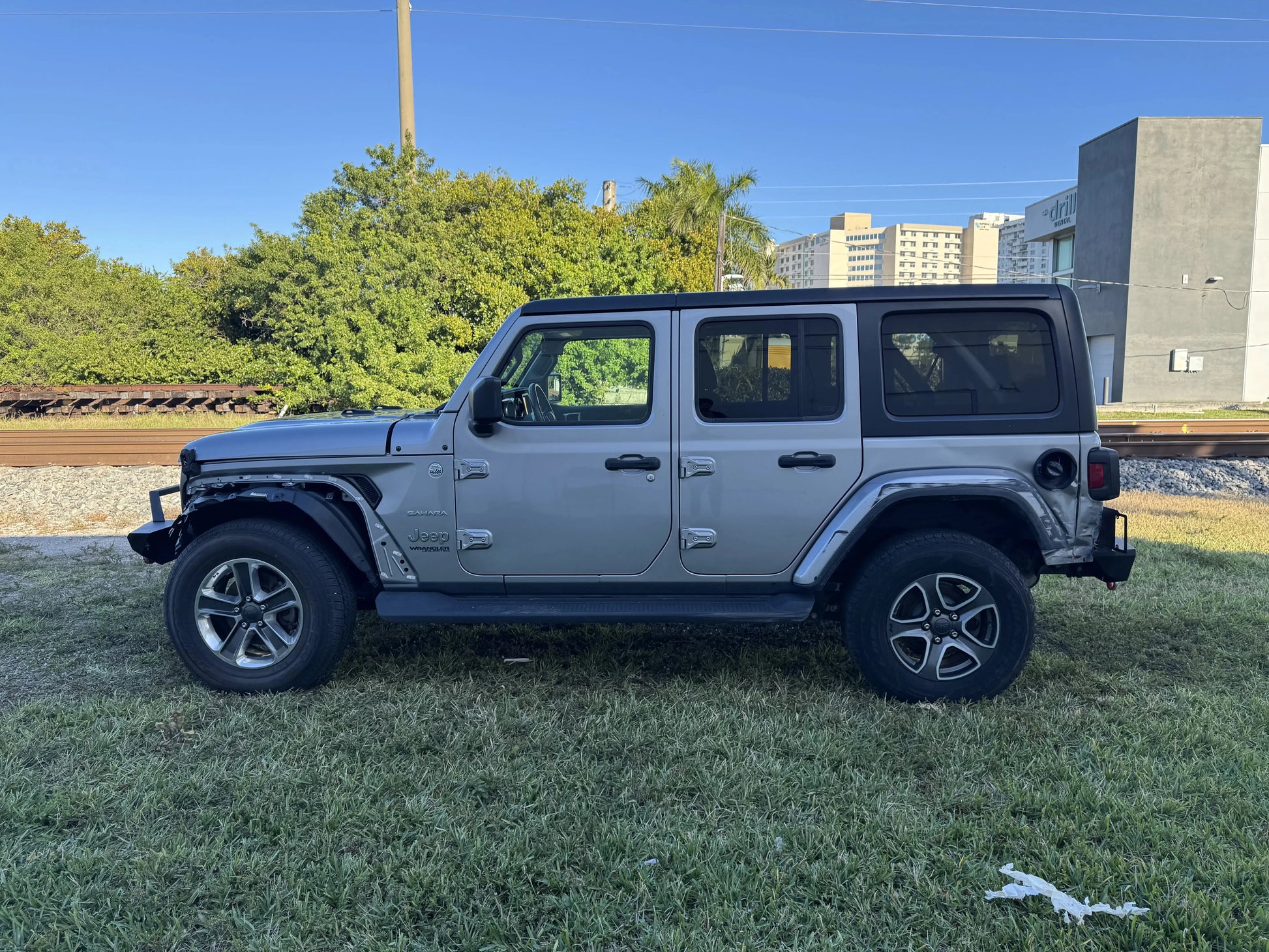 2020 Jeep Wrangler Sahara parked on grass, showcasing repairable features, available as a salvage car for sale