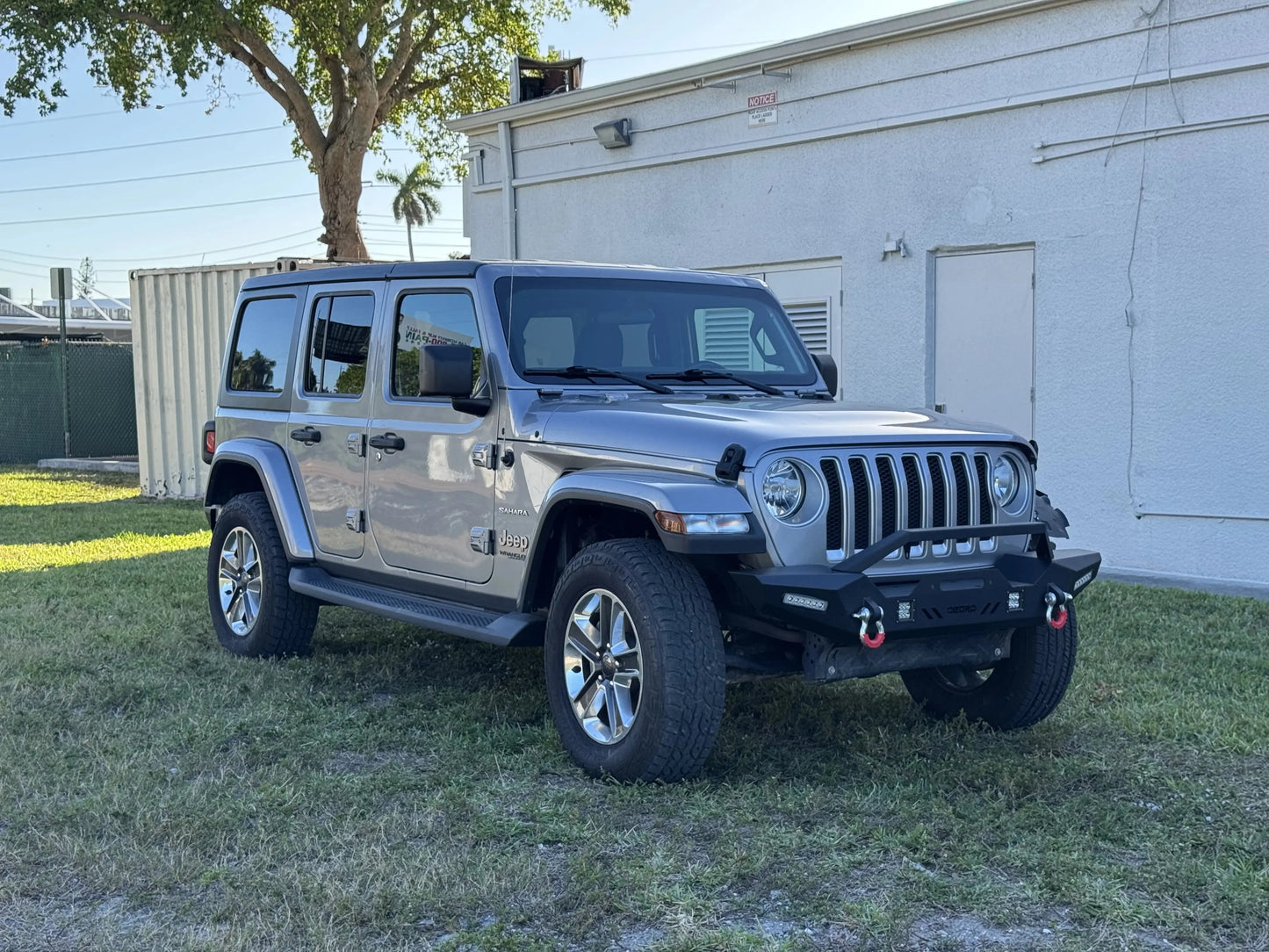 2020 Jeep Wrangler Sahara in gray exterior with off-road modifications, available as a repairable & salvage car for sale from Salvage Car Deal